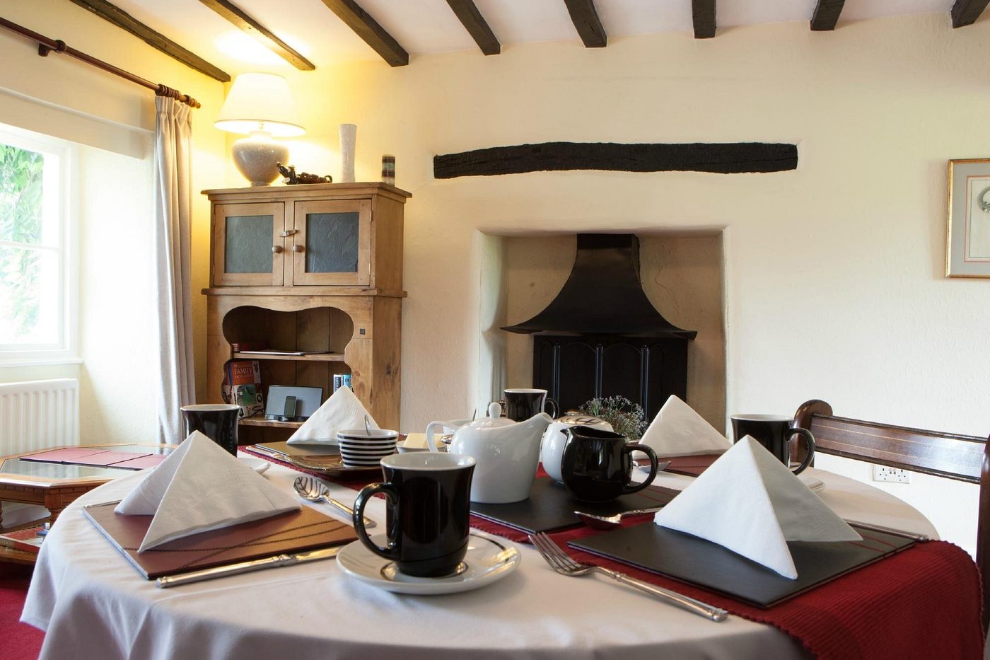 The breakfast room, set for breakfast by the fire